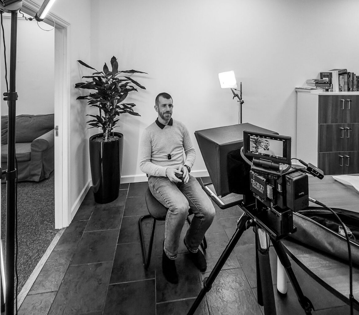 man in chair being recorded for video