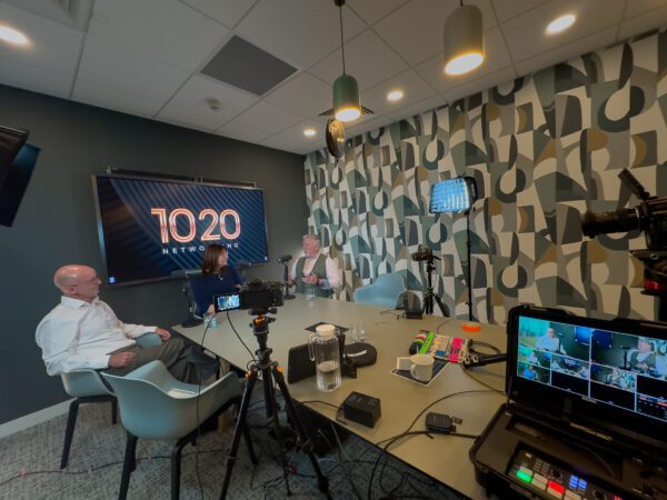 three people filming a podcast with 1020 branding